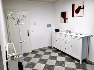 a white bedroom with a checkered floor at schöne, modernisierte Wohnung - Dudweiler in Saarbrücken