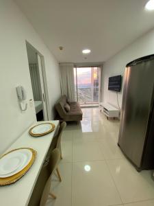 a kitchen and living room with a table and a couch at O melhor apartamento no shopping in Águas Claras