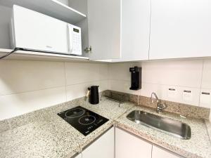 uma cozinha com um lavatório e um micro-ondas em O melhor apartamento no shopping em Águas Claras