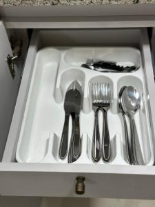 a drawer filled with utensils in a kitchen sink at O melhor apartamento no shopping in Águas Claras