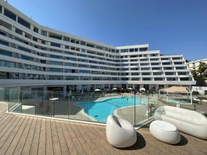 a large building with a swimming pool in front of it at Sea side 87 Sweet Me Eilat אילת in Eilat