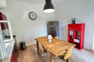 蒙彼利埃027-Maison, 2chambres, jardin, parking, central的厨房配有木桌和墙上的时钟 更多22张照片
