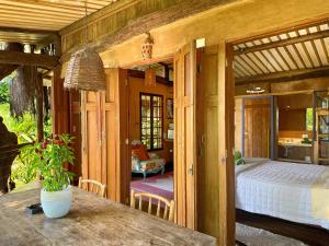 um quarto com uma cama e uma mesa num quarto em Casas D’Água Doce - Casa da Árvore em Ilhabela