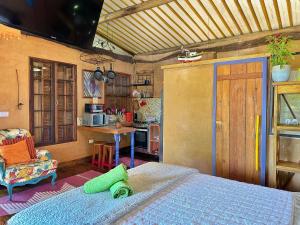 um quarto com uma cama e uma cozinha em Casas D’Água Doce - Casa da Árvore em Ilhabela