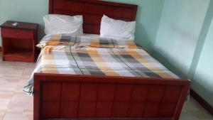 - un lit avec une couverture en damier dans l'établissement GSF Guest House, à Addis-Abeba