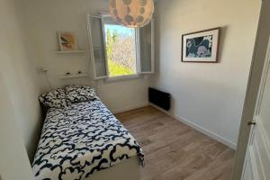 ein kleines Schlafzimmer mit einem Bett und einem Fenster in der Unterkunft Maison, 2chambres, jardin, parking, central,6pers in Montpellier