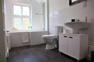 a white bathroom with a toilet and a sink at Victoria 4 bedroom Serviced House Short Lets - Near Northampton Gen Hosp & Town Centre in Northampton