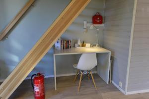 Habitación con escritorio y silla bajo una escalera. en Guesthouse in Manger, Radøy Island, en Kollstad