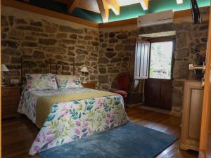 Un dormitorio con una cama y una pared de piedra. en Casa A Chairiña y A Revolta, en Arnoia 37 fotos más