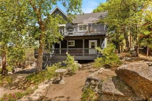 a large house with a balcony and a yard at Charming Getaway Cabin in Lake Arrowhead
