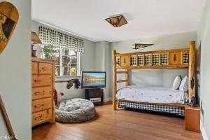 a bedroom with a bunk bed and a television at Charming Getaway Cabin in Lake Arrowhead