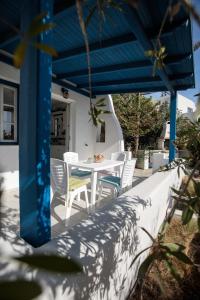 a table and chairs on a patio with a blue roof at Nefeli in blue in Plaka