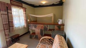 ein Wohnzimmer mit einem Sofa und einem Fenster in der Unterkunft Banda Lodge in Masaka