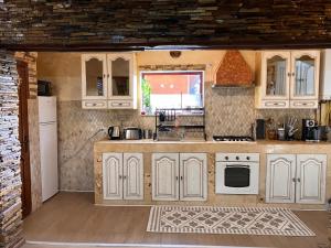a kitchen with white cabinets and a white stove top oven at Casa Odihnei Villa & Tiny-House in Tîrnăveni