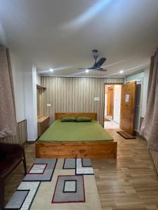 ein Schlafzimmer mit einem großen grünen Bett in einem Zimmer in der Unterkunft Dhauladhar Homes in Dharamshala