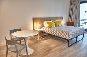 ein Hotelzimmer mit einem Bett, einem Tisch und Stühlen in der Unterkunft Babel Botánico in Buenos Aires