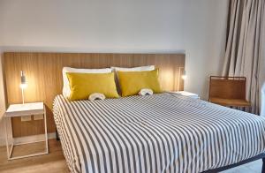 ein Schlafzimmer mit einem großen Bett mit gelben Kissen in der Unterkunft Babel Botánico in Buenos Aires