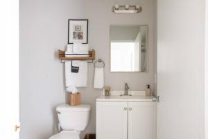 a bathroom with a toilet and a sink and a mirror at Flexhome Marquette Economy 2BR Apt MP4 - READ INFO in Milwaukee
