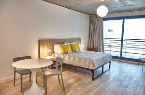 Schlafzimmer mit einem Bett und einem Tisch sowie einem Tisch und Stühlen in der Unterkunft Babel Botánico in Buenos Aires