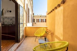 een balkon met twee gele stoelen en een raam bij iFlat Trevi Fountain's roomy&friendly apartment in Rome