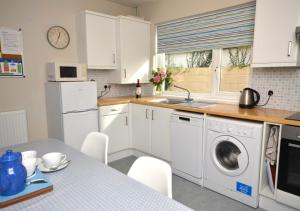 a kitchen with a sink and a washing machine at Preston Down in Paignton