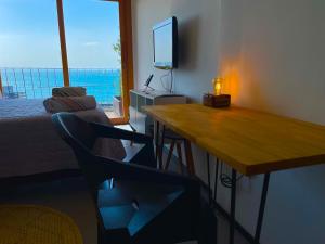 a room with a desk and a chair and a television at Studio da fonte/Vista mar in Salvador