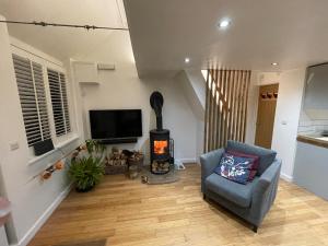 a living room with a chair and a stove at The Sail Loft - Hayling Island in South Hayling