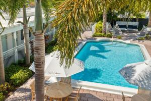 a swimming pool with chairs and a palm tree at Hotel Cabana Clearwater Beach in Clearwater Beach +5 photos