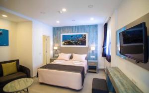 1 dormitorio con cama, sofá y TV en Queen Victoria Suit Apart OTEL, en Bodrum City