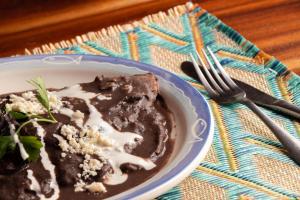 un plato de pudín de chocolate y un tenedor en una mesa en Casa Kundavi Beach Front Paradise en Recado