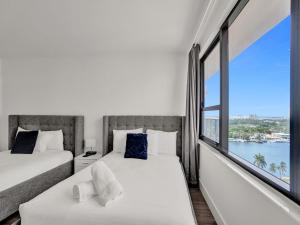 two beds in a room with a large window at Gorgeous Miami Beach Condo Beach Service 1614 in Miami Beach +40 photos
