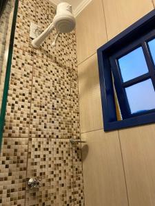a bathroom with a shower with a window at Cantinho caipira in Aparecida
