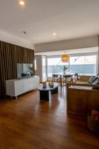 a living room with a couch and a tv and a table at Ushuaia Homes Downtown Apartments in Ushuaia