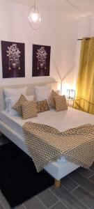 ein Schlafzimmer mit einem großen weißen Bett mit Kissen in der Unterkunft Cazino Apartamento III in Praia