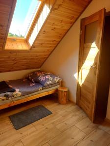a attic room with a bed and a window at Do Słońca in Ropienka