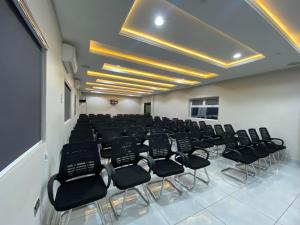 una sala conferenze con sedie nere in una stanza di Emmaag Hotel, Ibadan a Ibadan
