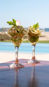 dos copas de vino llenas de comida en una mesa en Casa Kundavi Beach Front Paradise en Recado
