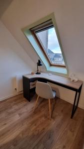 - un bureau avec une fenêtre et une chaise dans le grenier dans l'établissement Studio Babylone - Parking & Wifi, à Chartres