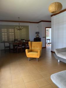 ein Wohnzimmer mit einem gelben Stuhl und einem Tisch in der Unterkunft Holiday Home Austry in Tejina