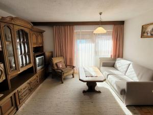 uma sala de estar com um sofá e uma televisão em Apartment Buntweg-1 by Interhome em Zams