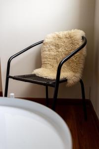 a chair with a furry pillow on it at Ushuaia Homes Downtown Apartments in Ushuaia