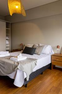 una camera da letto con un grande letto con asciugamani di Ushuaia Homes Downtown Apartments a Ushuaia