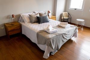 una camera da letto con un grande letto con due asciugamani di Ushuaia Homes Downtown Apartments a Ushuaia