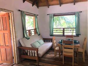 Maya Beach的住宿－Kin Resort Lodge，客房设有床、桌子和窗户。