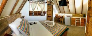 a room with a bed and a table and a window at Kin Resort Lodge in Maya Beach