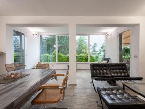 a living room with a table and chairs and windows at Holiday Home Il Roccolo by Interhome in Pettenasco