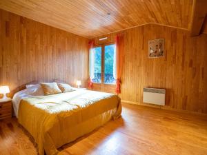 Un dormitorio con una cama con paredes de madera y una ventana en Chalet Mendiaux by Interhome, en Saint-Gervais-les-Bains