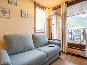 d'un salon avec un canapé et un balcon. dans l'établissement Apartment Le Mummery-4 by Interhome, à Chamonix-Mont-Blanc