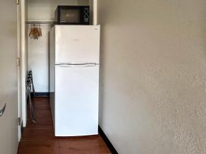 a white refrigerator in a hallway with a microwave at Motel 6 Ontario CA Convention Center Airport in Ontario