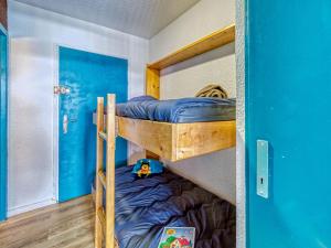 Cette chambre dispose de lits superposés avec 2 lits superposés et une porte bleue. dans l'établissement Apartment Les Eterlous by Interhome, à Val Thorens